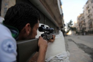 A fighter from the Syrian opposition aims fire during clashes with forces loyal to President Bashar Al-Assad, in the center of Syria's restive northern city of Aleppo (photo: AFP / BULENT KILIC)