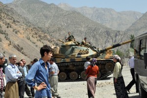 People stand near armoured vehicles of Turkish military stationed in front of Gecimli military outpost where Kurdish rebels attacked and killed 6 soldiers and 2 village guard on 5 August at Cukurca in Hakkari AFP PHOTO / STR