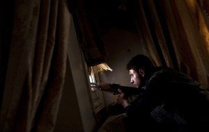 A member of the Free Syrian Army tries to spot positions held by government forces from a residential building on the outskirts of the Salaheddin neighbourhood of the northern Syrian city of Aleppo on 14 August AFP PHOTO / ACHILLEAS ZAVALLIS