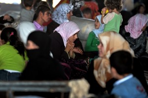 Syrian families which have been displaced due to fighting between rebel fighters and Syrian government forces are seen near the Syrian border with Turkey on 25 August AFP PHOTO / ARIS MESSINIS