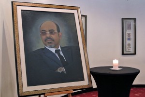 A candle burns beside a mural of late Ethiopia's Prime Minister, Meles Zenawi at a press conference by Ethiopian government spokesman Bereket Simon where he announced the death of Zenawi in Addis Ababa on 21 August