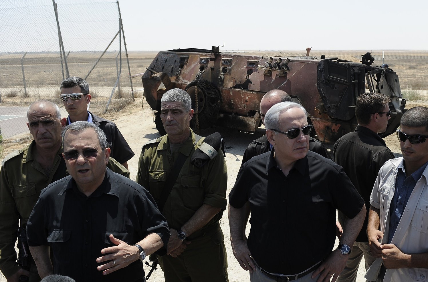 Israeli Defence Minister Ehud Barak (2nd L) and Prime Minister Benjamin Netanyahu (3rd R) speak to the press next to a burnt armoured vehicle near the Kerem Shalom border crossing after unidentified gunmen crossed into Israel from Egypt on 6 August AFP PHOTO / DAVID BUIMOVITCH