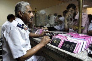 Egyptian custom officials check passports and identity cards as travellers wait on Egyptian side of the Rafah border crossing point on 10 August (AFP PHOTO/STR)