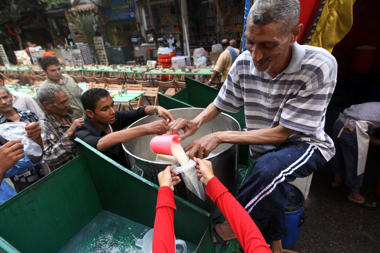 An Egyptian man distributes free milk for Muslims to break their day-long Ramadan fast during a group "Iftar" meal for the residents of a neighbourhood in downtown (File photo) AFP PHOTO / KHALED DESOUKI