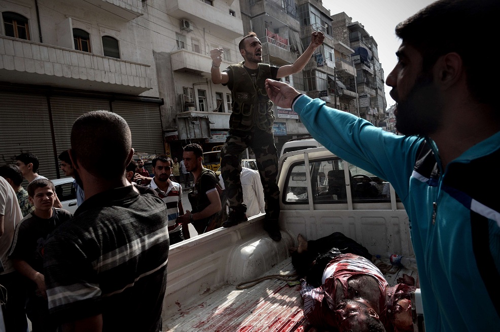 An opposition fighter shouts for help as he delivers the body of a civilian who was wounded during shelling by Syrian government forces outside a hospital in Syria's northern city of Aleppo AFP PHOTO / ARIS MESSINIS