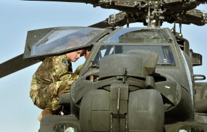 Britain's Prince Harry examines the interior of an Apache helicopter with a member of his 622 Squadron at Camp Bastion in Helmand Province, Afghanistan on 7 September AFP PHOTO / POOL / JOHN STILLWELL