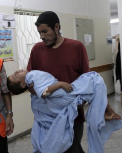 A man carries a Palestinian child to be treated for wounds on 10 September at the Al-Najjar hospital in Rafah, southern Gaza Strip AFP PHOTO/ SAID KHATIB