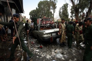 Yemeni security forces surround the wreckage of a car following a car bomb attack targeting the convoy of the country's defense minister in Sanaa AFP PHOTO / MOHAMMED HUWAIS