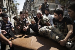 Syrian rebels help a wounded comrade who survived a Syrian army strike outside a hospital in the northern city of Aleppo on 18 September AFP PHOTO / MARCO LONGARI