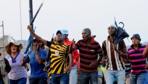 Striking miners holding umbrellas celebrate securing a 22 percent pay hike from London-listed Lonmin platinum mine in Marikana AFP PHOTO / ALEXANDER JOE
