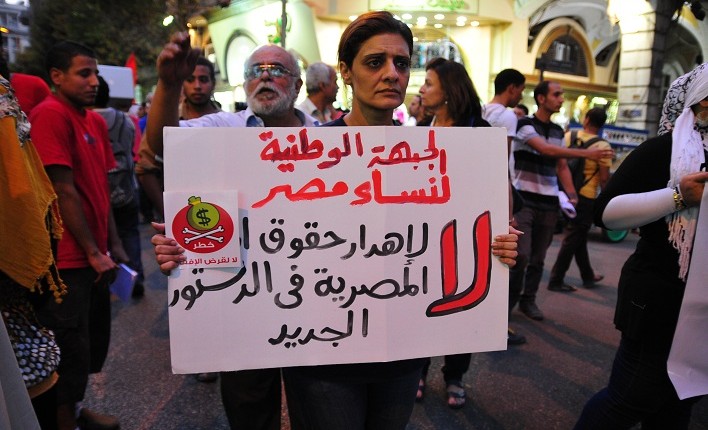 A supporter of the National Front for Egyptian Women joins a march from Talaat Harb Square holding a sign that says “no to wasting women’s rights in the new constitution“ Hassan Ibrahim / DNE