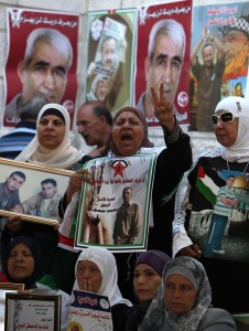 Palestinian women hold pictures of their relatives held in Israeli jails during a sit-in outside the Red Crescent offices near the West Bank city of Ramallah on 18 September (File photo) AFP PHOTO / ABBAS MOMANI