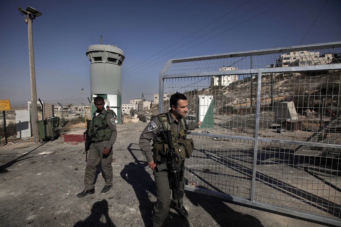 Israeli soldiers stand guard at Ras Khamis checkpoint in east Jerusalem on 20 September. Check points and walls are just some of the impediments imposed by the Israeli authorities on the economic cohesion of the Palestinian territories AFP PHOTO / AHMAD GHARABLI