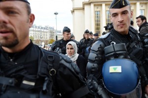 French mobile policemen escort a Muslim woman for an identity control in Paris as police deployed in several areas of the city to enforce a ban on protests over films and cartoons mocking the Prophet Mohammed AFP PHOTO / ERIC FEFERBERG