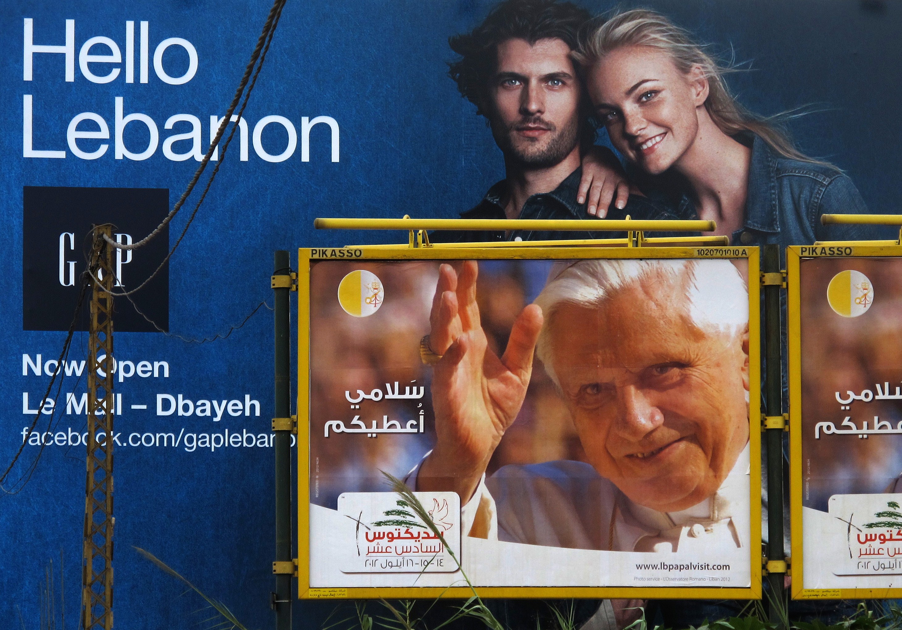 A poster welcoming Pope Benedict XVI appears under an billboard advertisement for a retail shop on the Dbayeh highway, north of Beirut AFP PHOTO / PATRICK BAZ