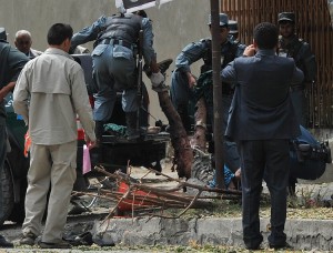 Afghan policemen carry the remains of a suicide attack victim in the city's diplomatic quarters in Kabul AFP PHOTO/ SHAH MARAI