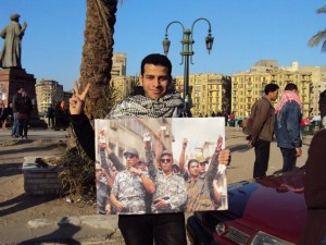 Protester on Tahrir Square carries an image of the 8 April officers 8 April group