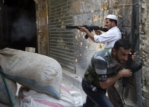 A Syrian rebel fires towards regime forces as his comrade ducks for cover during clashes in the old city of Aleppo in northern Syria AFP PHOTO / MIGUEL MEDINA
