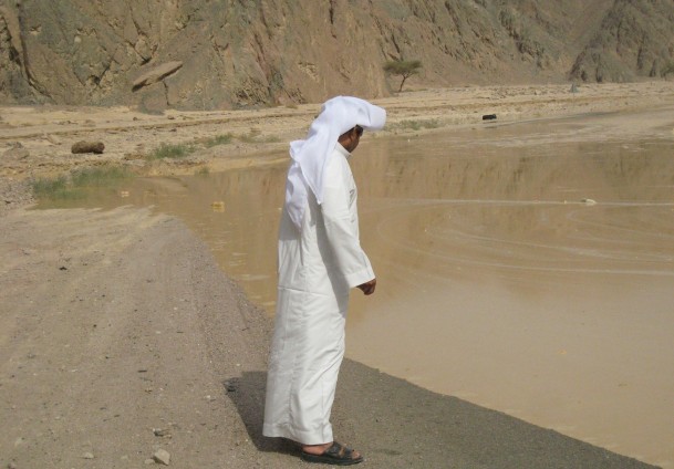 Man watches the flood waters near Nuweiba Nasser El-Azazy