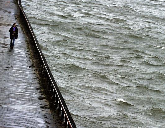 A woman walks down the promenade along the East River in New York on October 29, 2012 as New Yorkers venture out as Hurricane Sandy prepares to make landfall. (Timothy A. Clary / AFP / Getty Images)