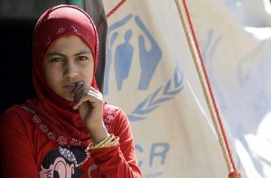 A Syrian refugee girl, who fled the violence in her country, stands outside the Bashabsha camp near the Jordanian city of Ramtha, close to the Syrian border AFP Photo / Khalil Mazraawi
