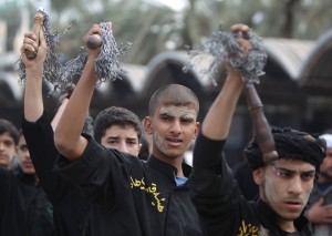 Smeared with mud, Shiite Muslim pilgrims beat themselves with metal chains as they take part in a parade in preparation for the peak of the Ashura ceremony, near the shrine of Imam Hussein in Karbala, some 80 kilometers (50 miles) southwest of Baghdad, on 24 November. (AFP PHOTO / AHMAD AL-RUBAYE)