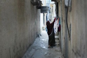 A Palestinian woman hangs laundry outside her house at the Shati Palestinian refugee camp in Gaza City on 3 November. (AFP PHOTO / MAHMUD HAMS )