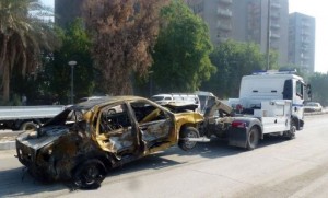 A damaged vehicle is towed away following a car bomb near Firdos Square in Baghdad on November 14 (AFP, Sabah Arar)
