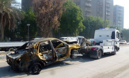 A damaged vehicle is towed away following a car bomb near Firdos Square in Baghdad on November 14 (AFP, Sabah Arar)