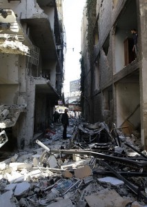 Syrian men inspect an alley packed with debris in the aftermath of a car bomb explosion in Jaramana, a mainly Christian and Druze suburb of Damascus, on 28 November. (AFP PHOTO / LOUAI BESHARA)
