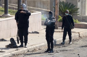 A police office fires a tear gas canister towards protesters during clashes near Tahrir Square on 29 January AFP Photo / Khaled Desouki
