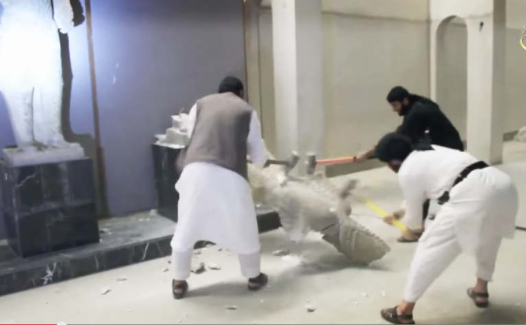 ISIS while destroying statues in Iraq (Photo from youtube)