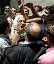 An Egyptian woman screams as she and other members of the left-wing umbrella organization Kefaya (Enough) are roughed-up by supporters of Egyptian President Hosni Mubarak while participating in a protest in Cairo against the referendum on changing the electoral system on 2005. (AFP File Photo /Cris Bouroncle)