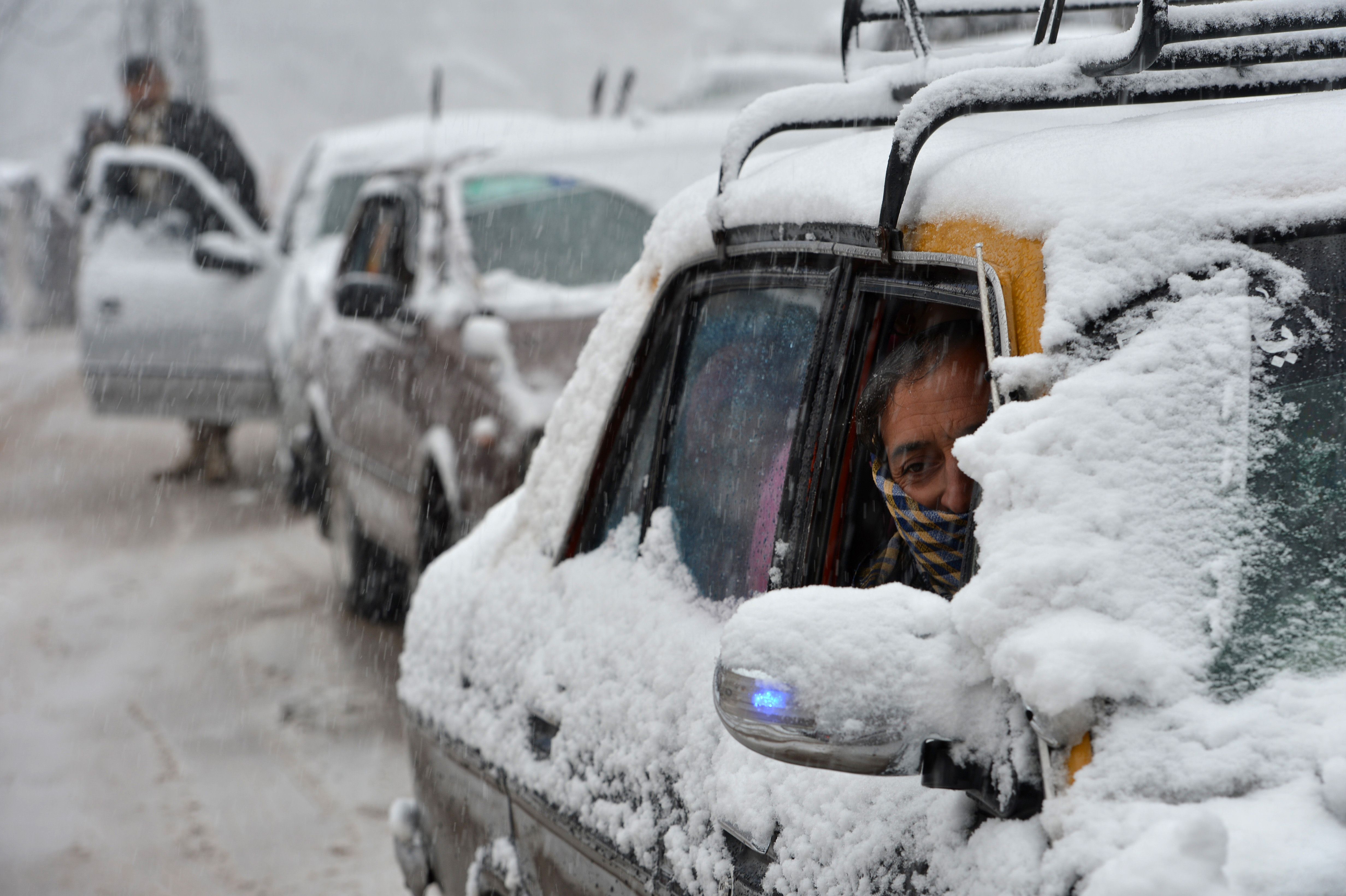 A Pakistani taxi driver steers his vechile during a snowfall in Murree, some 70 kilometers from Islamabad on 8 January 2014. The season's first snow fell in Murree and adjoining areas. (AFP PHOTO/Farooq NAEEM)