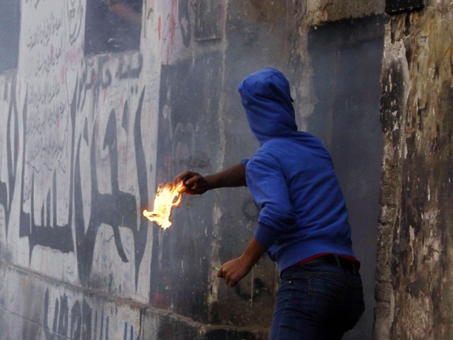 A young Egyptian protester throws a molotov cocktail into a building during clashes in the Cairo's Mohammed Mahmoud street on November 22, 2012 (AFP/ file photo)