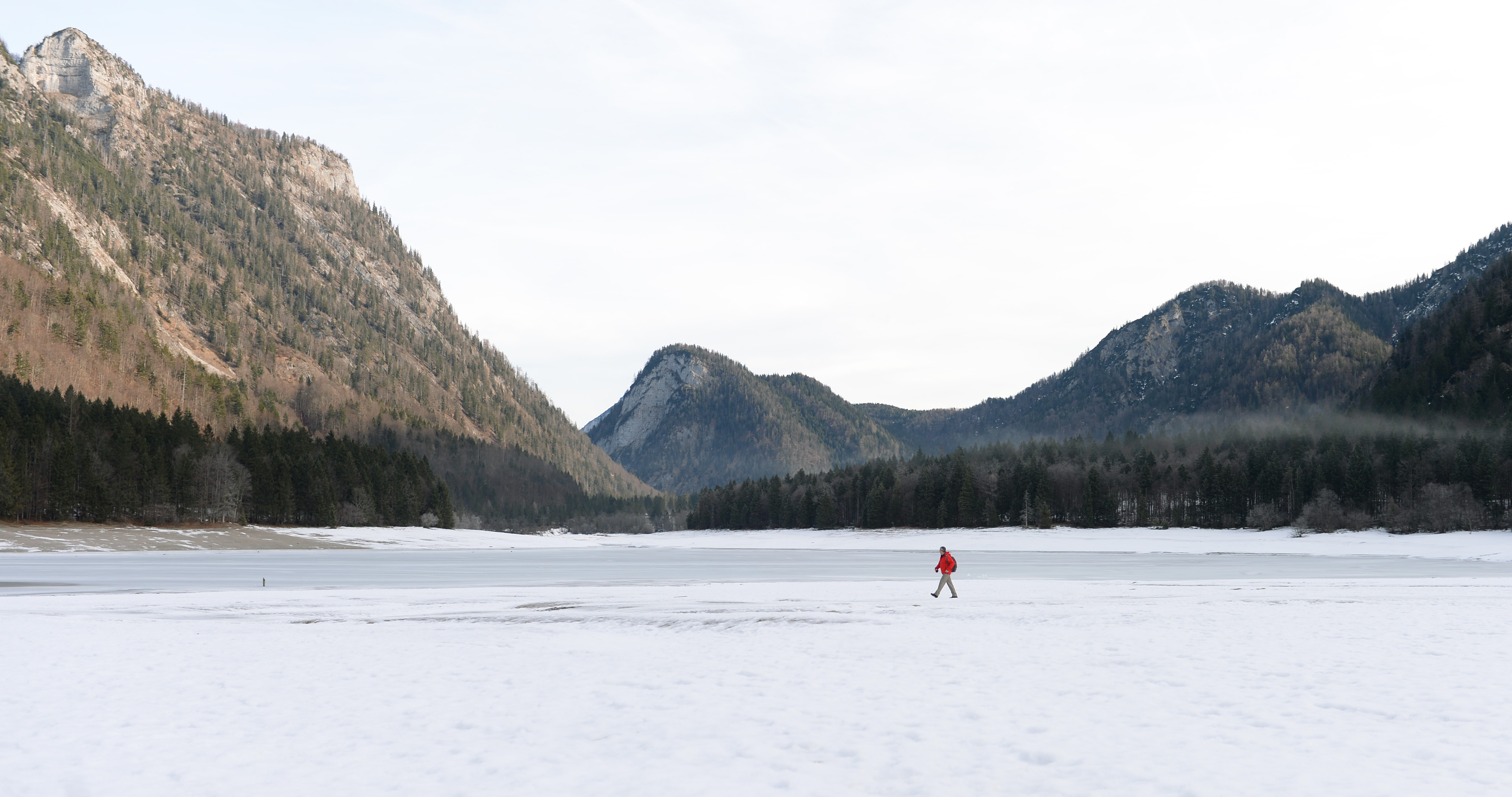 A pedestrian walks beside a frozen lake at the so-called "Drei Seen Land" (three lakes area) near the village Ruhpolding, southern Germany, on 9 January 2014. (AFP PHOTO)
