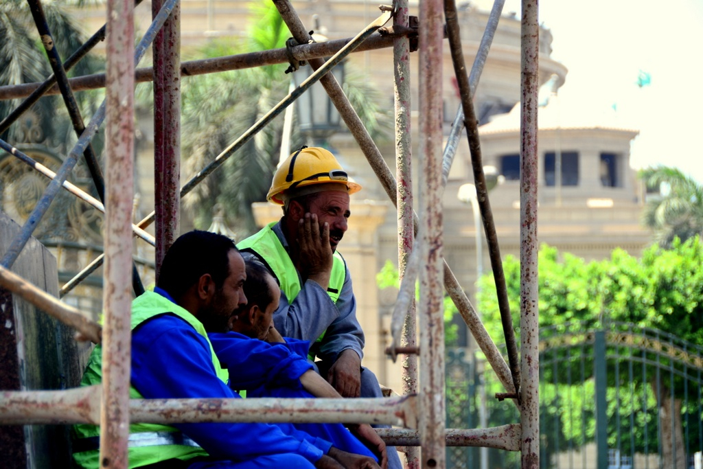 Workers take a break on the scaffolding surrounding the statue and look out over what once was the Al-Nahda sit-in, Photo by Aaron T. Rose