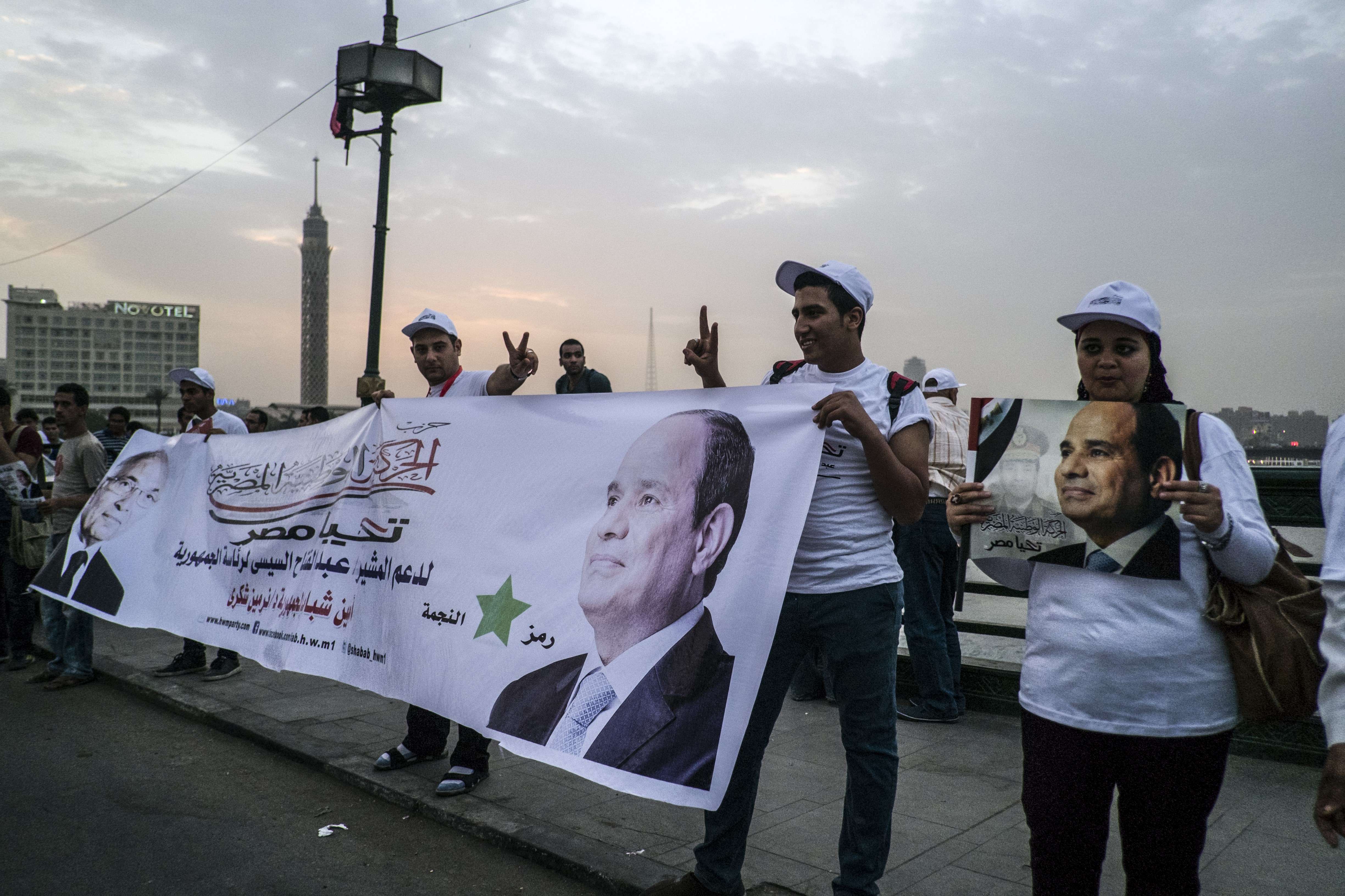 Egyptians hold banners bearing images of Egypt's ex-army chief and presidential candidate Abdel Fattah al-Sisi during a rally in support of Sisi on the Qasr el-Nile bridge in Cairo on May 20, 2014. Sisi is expected to romp home in this month's presidential election, but his challenge will be fighting poverty and rebuilding the shattered economy. (AFP PHOTO / KHALED DESOUKI)