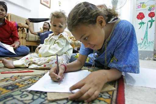 A 13-year-old girl draws a picture as her sister sits close by in an all-girls rehabilitation shelter in Cairo (AFP File photo)