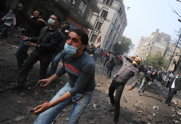 Egyptian youths, wearing masks to protect against tear gas, throw stones during the 2011 Mohamed Mahmoud Street clashes. (AFP/file photo)
