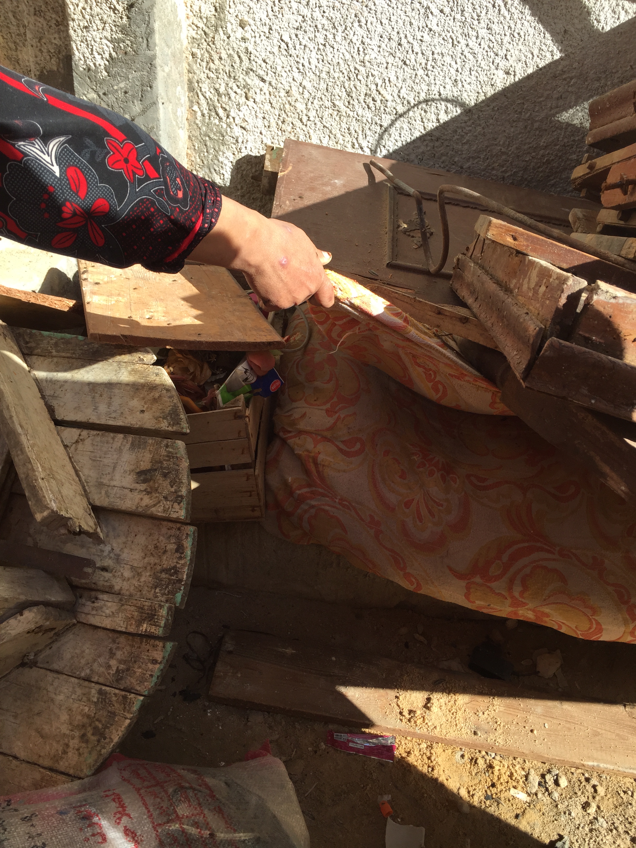 A woman tries to pull out her buried mattress from under the remnants of waterlogged furniture in Abdelkader village near Alexandria