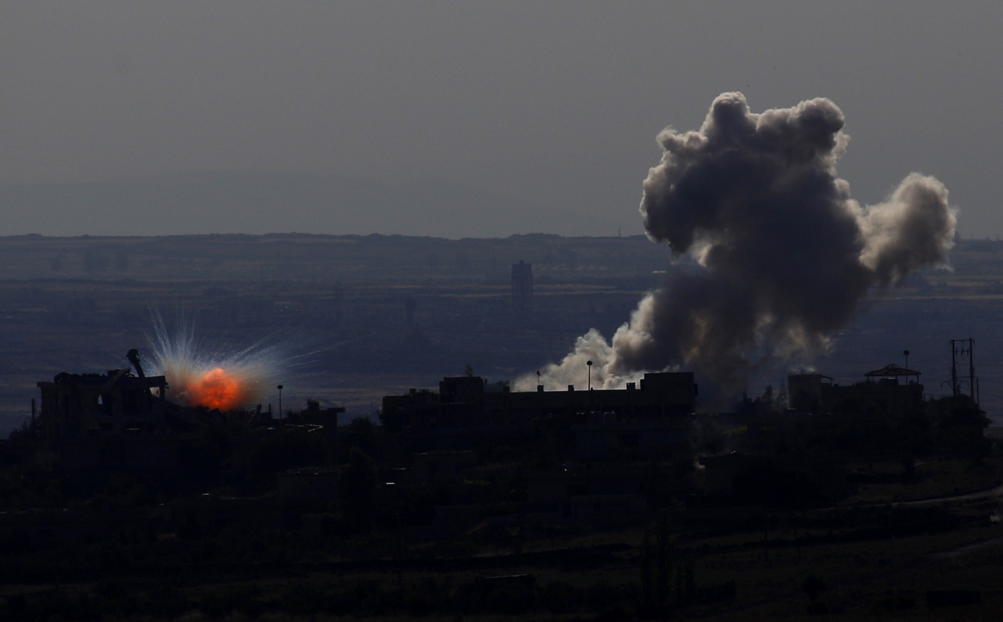 A picture taken on May 11, 2014 from the Israeli-annexed Syrian Golan Heights shows smoke billowing from an explosion during clashes between rebels and Syrian pro-government forces in the Syrian town of al-Kahtaniyya. The rebels had announced on their social networking pages the beginning of their military operations to control the border town al-Kahtaiyya and the Quneitra crossing. (AFP PHOTO / JALAA MAREY)