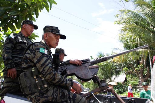 File photo taken on February 11, 2013 shows MILF rebels standing guard near the venue where Philippine President Benigno Aquino will be attending a ceremony as part of his visit to the rebels' stronghold in Sultan Kudarat on Mindanao island (AFP/File, Richele Umel)