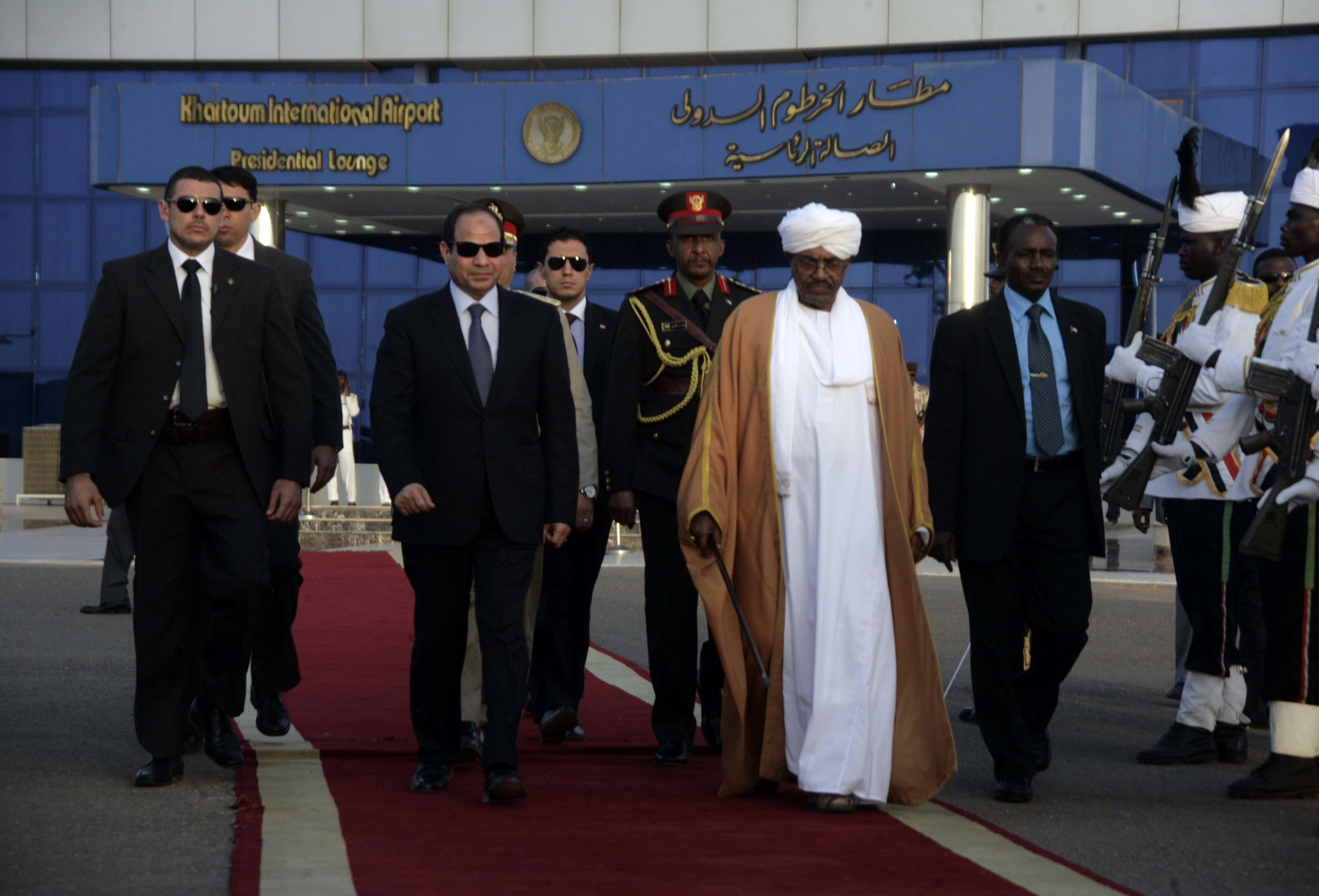 Egyptian President Abdel Fattah al-Sisi (C-L) and Sudanese President Omar al-Bashir leave the presidential lounge after a press conference upon Sisi's arrival at Khartoum airport for an official visit on June 27, 2014. (AFP PHOTO / EBRAHIM HAMID)