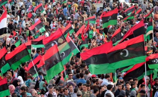 Libyans wave the country's new national flag as they celebrate in Benghazi. (AFP Photo)
