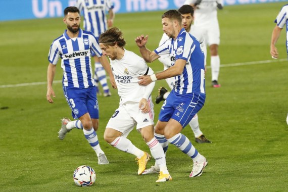 Alaves' Florian Lejeune (R) vies with Real Madrid Luka Modric (C) during a Spanish football league match between Real Madrid and Deportivo Alaves in Madrid, Spain, Nov. 28, 2020. (Photo by Edward F. Peters/Xinhua)