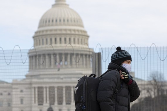 A man wearing a face mask walks past the U.S. Capitol building in Washington, D.C., the United States, Jan. 24, 2021. Amid surge in US COVID-19 cases (Photo by Aaron Schwartz/Xinhua)